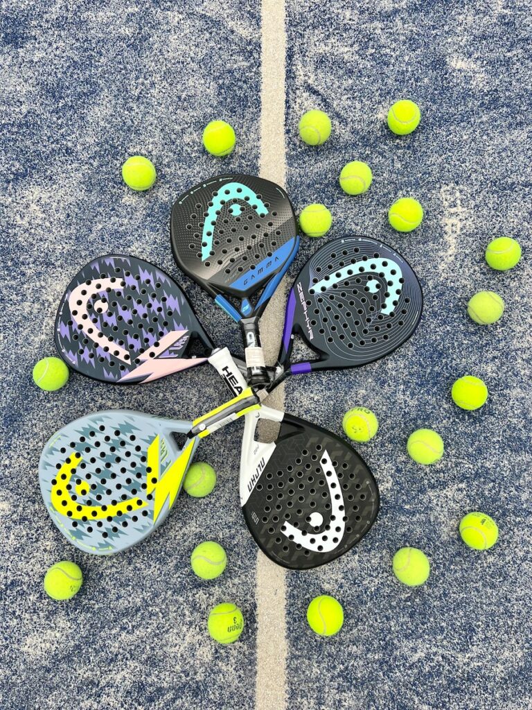 Two padel training players in action, expertly hitting the ball with their rackets and pala on a professional padel court, showcasing the excitement and strategy of the sport in a blog post about padel tips and techniques.